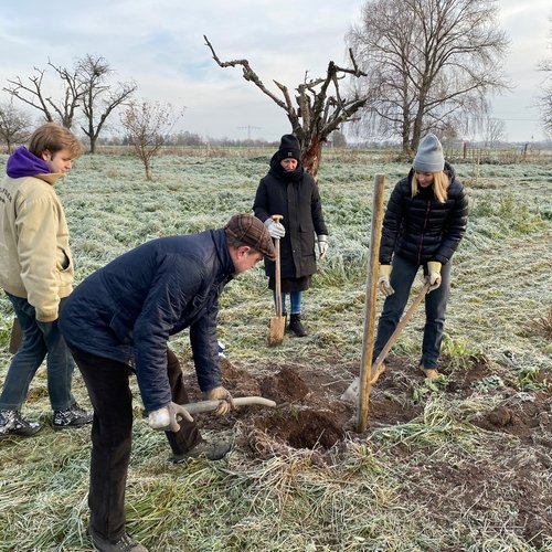 Mitarbeiter der Erdgas Südwest mit Helfern bei einer Baumpflanzaktion