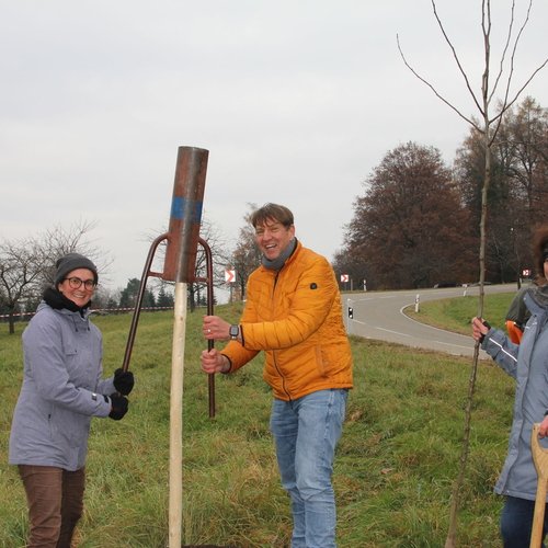 Zu sehen sind Helfer und Mitarbeiter der Erdgas Südwest beim Pflanzen eines Baumes