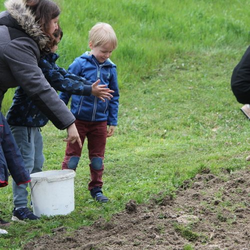 Mitarbeiter der Erdgas Südwest mit Kindern bei einer Baumpflanzaktion