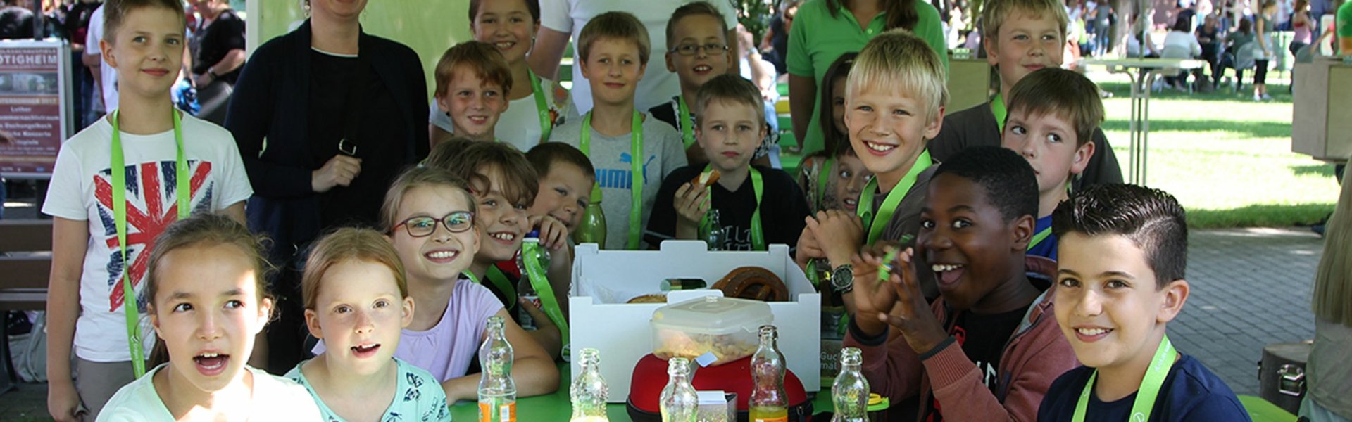 Grundschulen Malwettbewerb „Dschungelbuch trifft Hübi“: Gruppenbild aller Gewinner an einem grünen Tisch