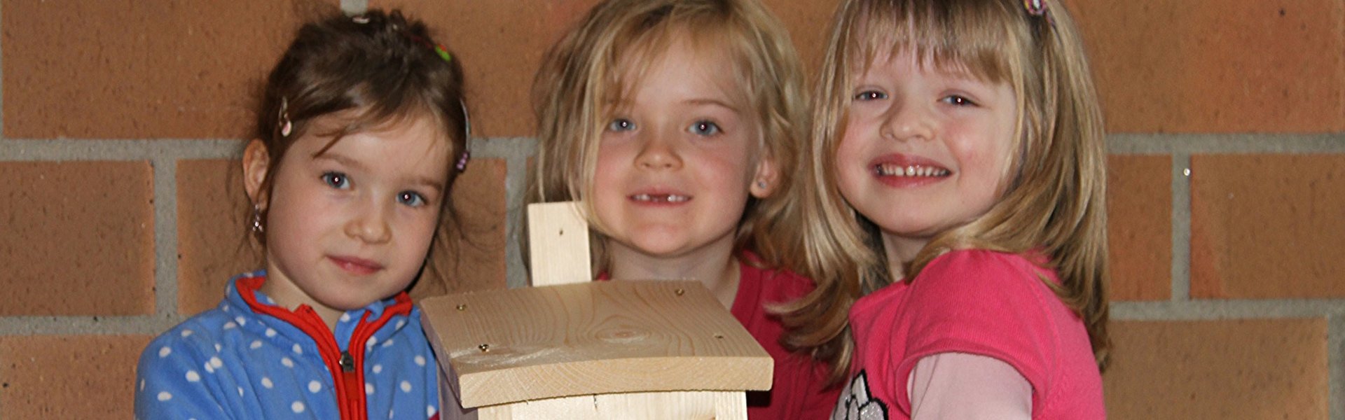 ProNatur Aktion: drei kleine Mädchen vom Kindergarten Stettfeld gemeinsam mit Vogelnistkästen