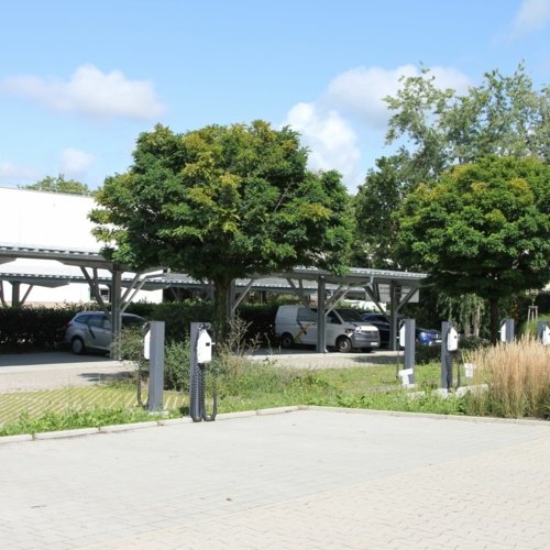 Außenaufname der Rückseite des Hauptsitzes der Erdgas Südwest in Ettlingen - im Fokus stehen die Lademöglichkleiten auf dem Parkplatz.