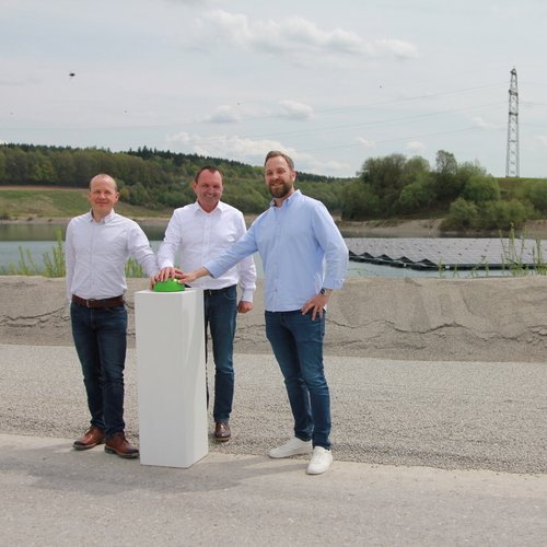 Geschäftsführung und Mitarbeiter feiern die Einweihung einer schwimmenden PV-Anlage