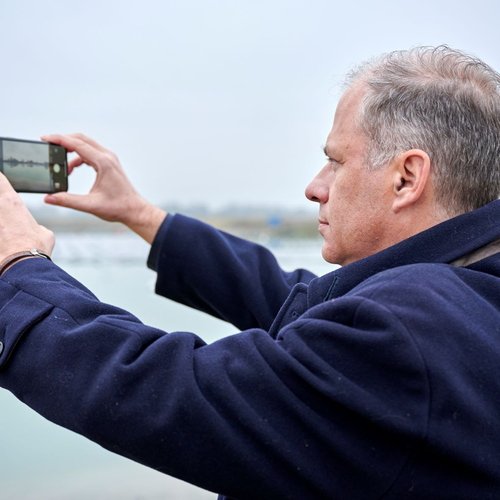 Ein Mann macht ein Bild von der schwimmenden PV Anlage