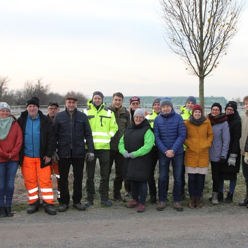 Mitarbeiter der Erdgas Südwest und Helfer stehen zu einem Gruppenfoto zusammen, das im Rahmen einer Baumpflanzaktion der Erdgas Südwest entstanden ist